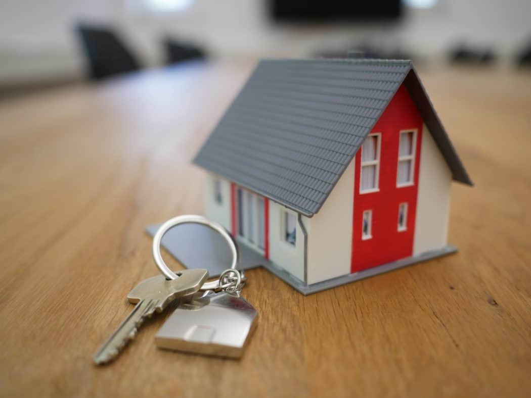 A small home used as a key chain sitting on a table