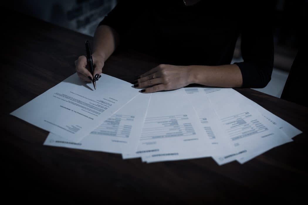 Person looking over tax forms spread out across a table