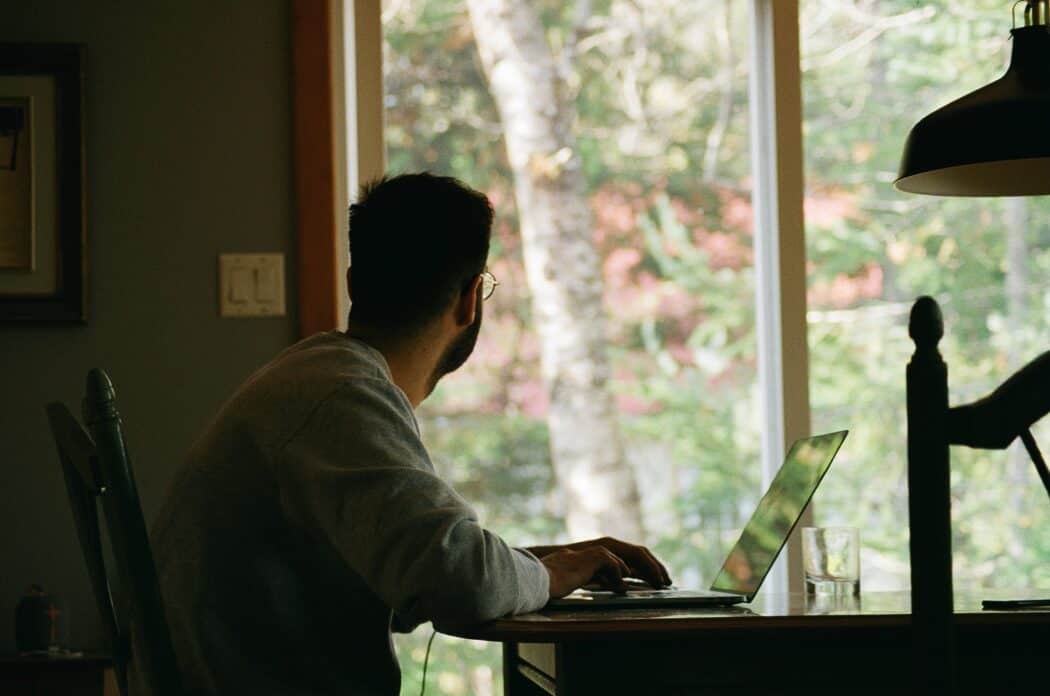 Image of person looking out window while working at home office