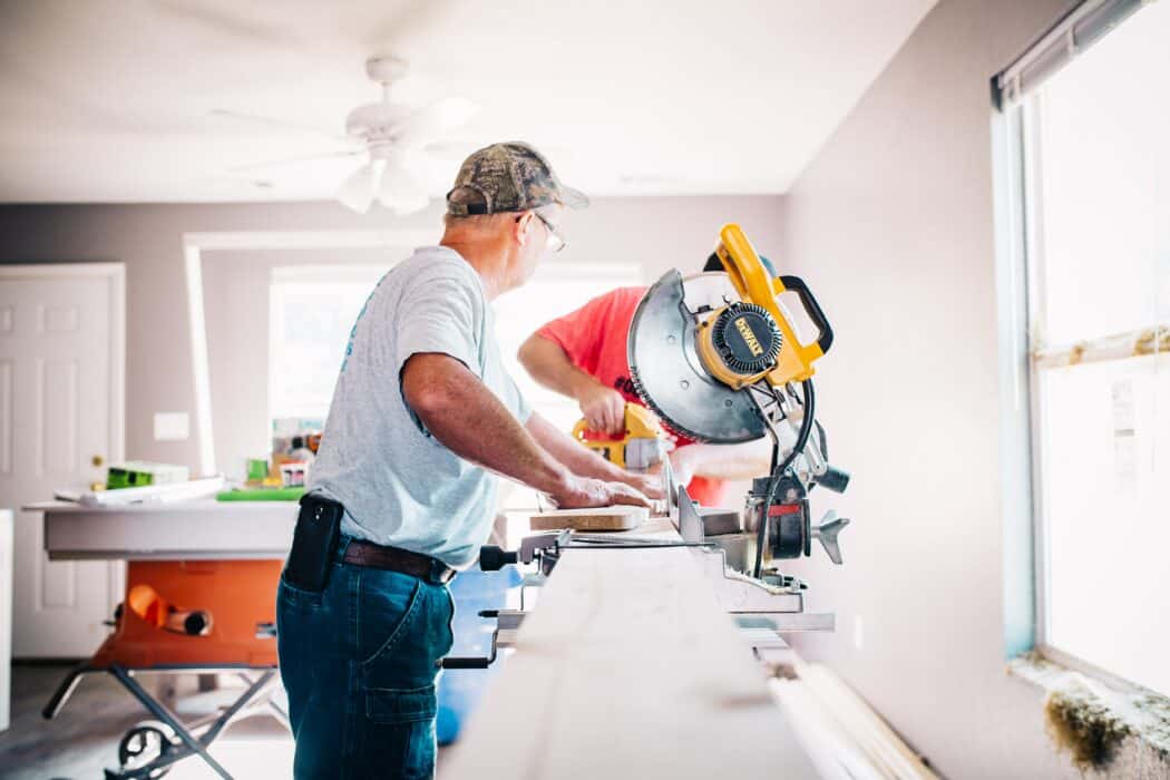 Workers completing a home improvement project in a bright living room