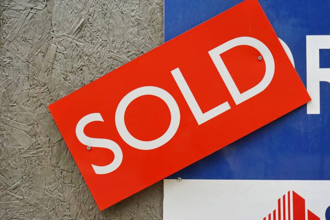 A red real estate "sold" sign